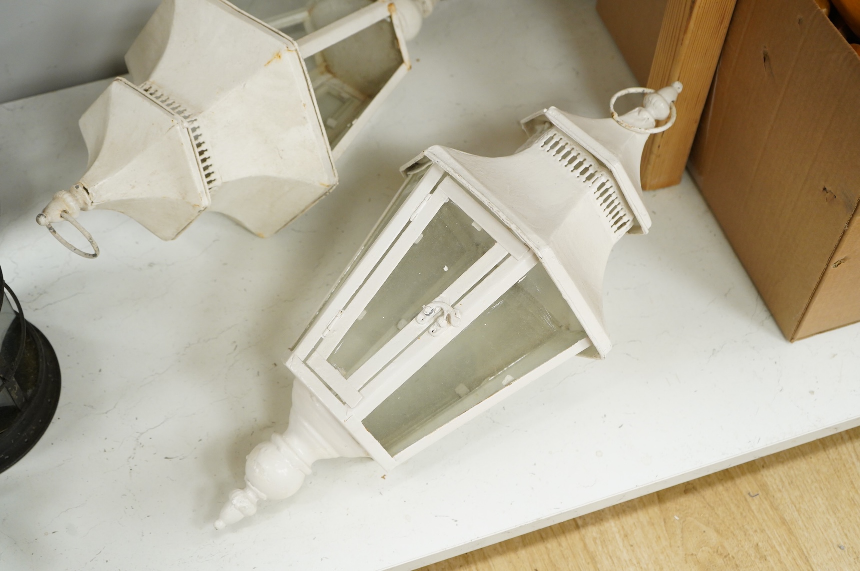 A pair of hexagonal painted hanging lanterns with glass panels, 54cm high